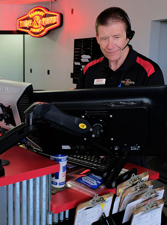 Mechanic talk on the phone behind the desk - Kearney Tire & Auto Service